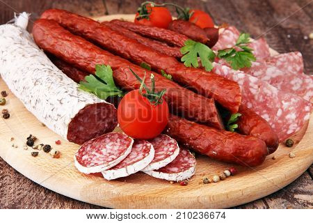 Food tray with delicious salami pieces of sliced ham sausage tomatoes salad and vegetable - Meat platter with selection - Cutting sausage and cured meat