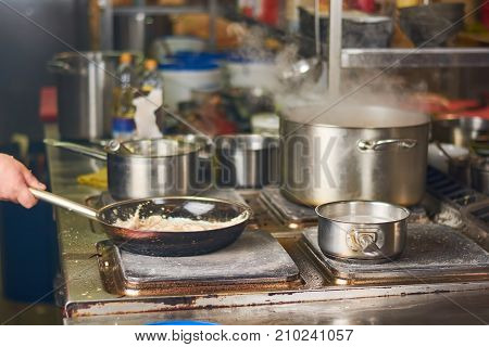 Man cooking at commercial kitchen. Man preparing food at residence kitchen. Man cooking at home.