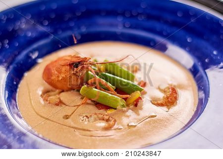 Tasty cream soup with crayfish. Vegetable cream soup with crayfish tails close up. Delicious dinner with sea products.