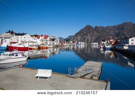 Henningsvaer Norway - August 19 2017: Picturesque fishing port in Henningsvaer on Lofoten islands Norway with typical red wooden buildings and small fishing boats