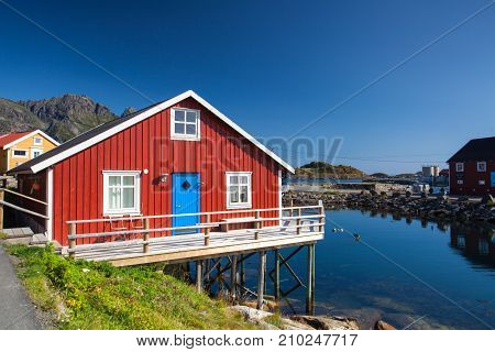 Henningsvaer Norway - August 192017: Picturesque fishing port in Henningsvaer on Lofoten islands Norway with typical red wooden buildings and small fishing boats