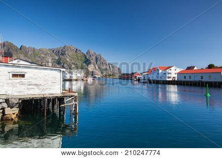 Henningsvaer Norway - August 192017: Picturesque fishing port in Henningsvaer on Lofoten islands Norway with typical red wooden buildings and small fishing boats