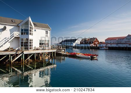 Henningsvaer Norway - August 19 2017: Picturesque fishing port in Henningsvaer on Lofoten islands Norway with typical red wooden buildings and small fishing boats