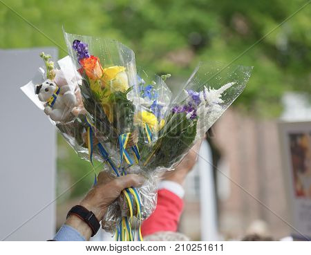 STOCKHOLM SWEDEN - JUN 13 2017: Hand holding flowers to a graduating student in the air at the dance school BalettakademienJune 13 2017StockholmSweden