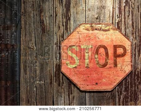 vintage Stop sign with old wood panels wall as background