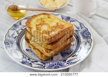French Toast Served With Honey And Cheese.