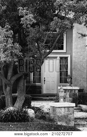 Black and White Entrance to Home with Tree Door Pathway and Pilasters