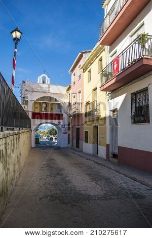 OLIVA, VALENCIA, SPAIN, 15TH JANUARY 2017 - Colourful buildings and gate chapel of Saint Vincent (San Vicente). The city gate is the oldest access route into the medieval city of Oliva Valencia Spain