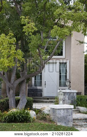 Pathway to Front Door of Home with Pilasters Tree and Curb Appeal