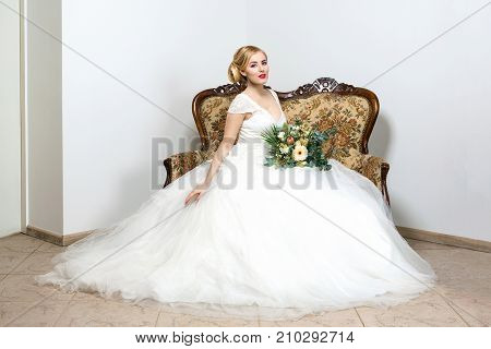 beautiful blond young woman in white wedding gown. bride with fashion hairstyle. studio shot.