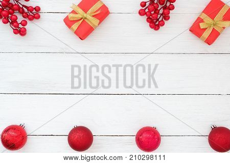 Christmas theme Background. Christmas present red gifts box holly berry and red christmas balls on white wooden board. Creative Flat layout and top view composition