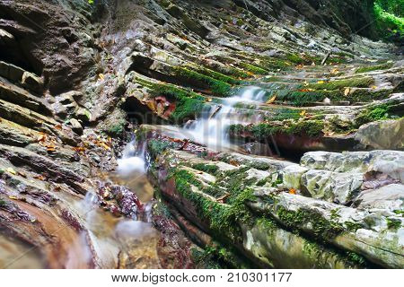 Glorious rocks with a old moss and flowing streams of the mountain creek