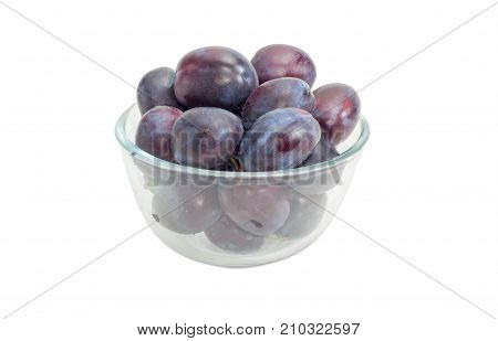 Ripe Victoria plums in a transparent glass bowl closeup on a white background
