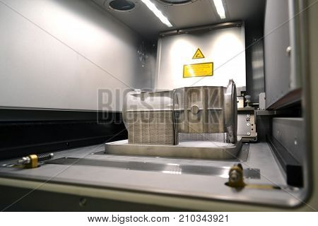A model with supports created in a laser sintering machine stays in the working chamber. DMLS, SLM, SLS technology. Concept of 4.0 industrial revolution. Progressive modern additive technology.