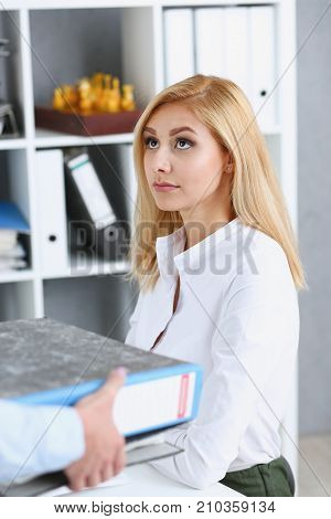 Female employee show pack of documents to busy manager or boss give extra work to executor. White collar portrait contract approval headache and depression irs lot of new problems concept