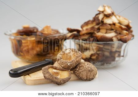 Dry Shitake Mushroom Or Lentnus Edodes And Knife Place On Chopping Board Have Blur Mushroom Soak And