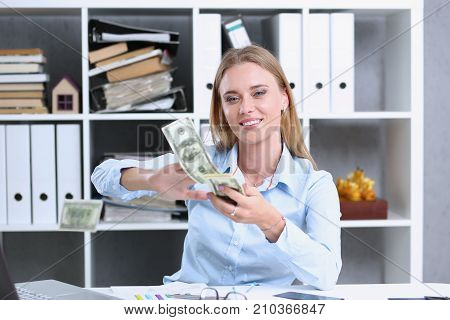 Beautiful businesswoman portrait. Scattering money notes dollars in fashion vows style  curly hair with white locks eye view of the camera