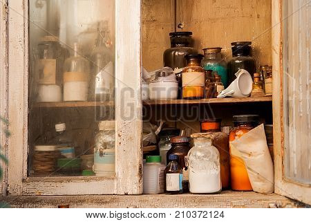 Vintage image of still life compositionglass chemical bottle in wooden cupboard
