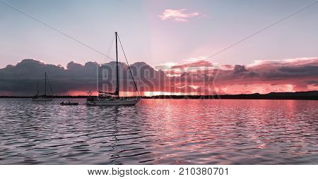 A striking inspirational ( colors ) colored cloudy sunrise seascape over sea water with water reflections. Captured inAustralia.