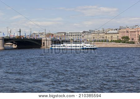 St. Petersburg, Russia - June 17, 2017: Two-deck motor ship Moscow-55 runs along the Neva River against the background of the Exchange Bridge and Mytninskaya Embankment in St. Petersburg