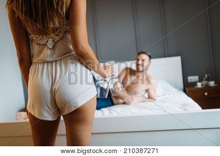 Attractive sexy woman with her handsome partner in bedroom