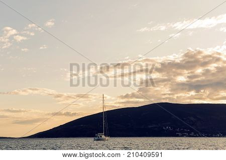 yacht docked at the pier in the Bay of Montenegro at sunset and mountain