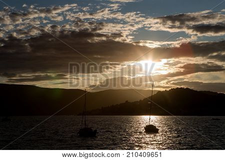 yachts docked at the pier in the Bay of Montenegro at sunset and mountain