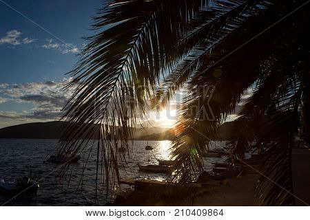 boats and yachts docked at the pier in the Bay of Montenegro at sunset and mountains in the background