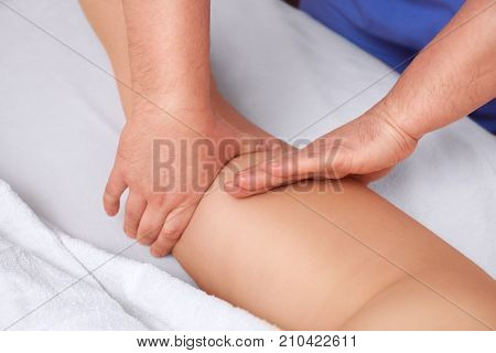 The masseur makes Anti-cellulite massage on the buttock and thighs of the patient. Treatment of excess weight.