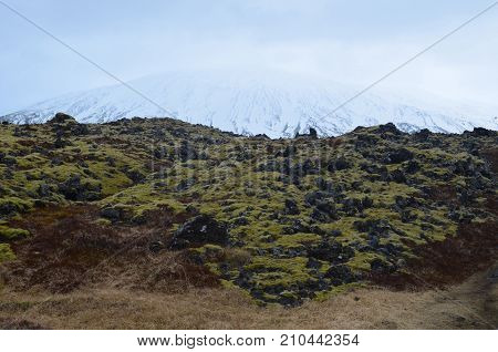 Beautiful Icecapped Mountain Emerging From A Lava Field In Iceland