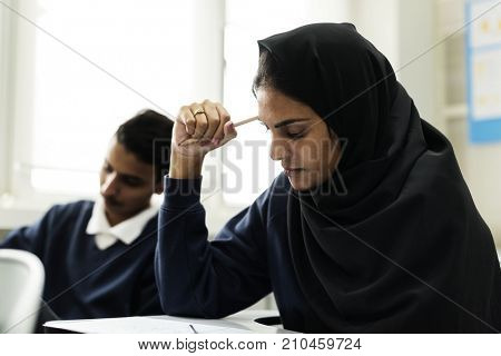 diverse muslim children studying in classroom