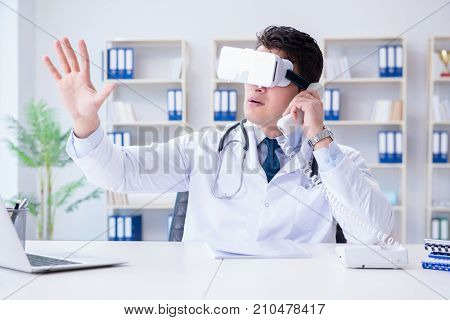 Young doctor with vr virtual reality headset working in the offi