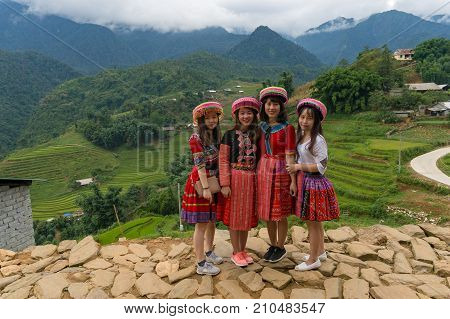 Asian Tourists In Vietnamese Traditional Clothe Posing Against Rural Background