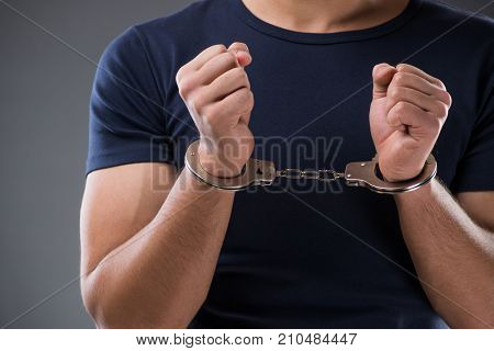 Man with his hands handcuffed in criminal concept