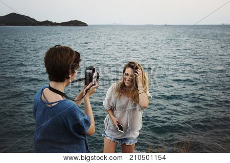Women taking photo by seashore