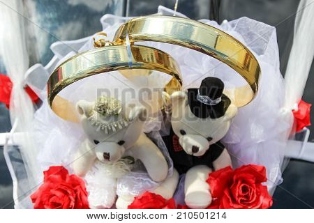 Decoration on car (wedding rings and couple of teddy bears)