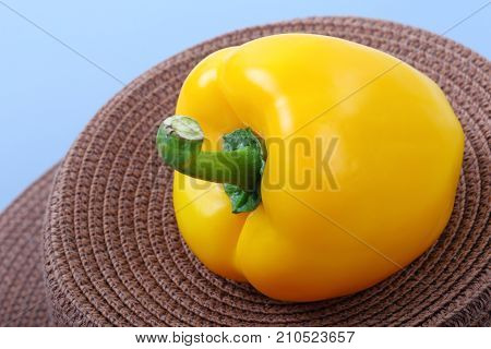 Close up of sweet yellow bell pepper isolated on sack and blue background.