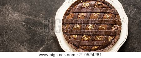 Chocolate Tart Pie Topped with Hazelnuts on Dark Stone Table Background