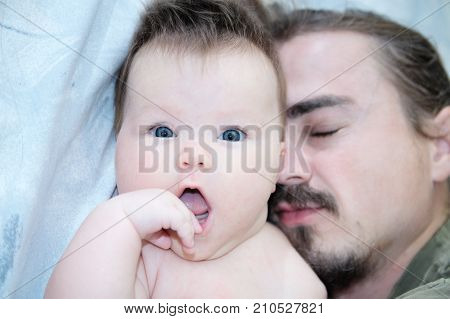 sleeping parent and baby portrait lying on bed together happy family