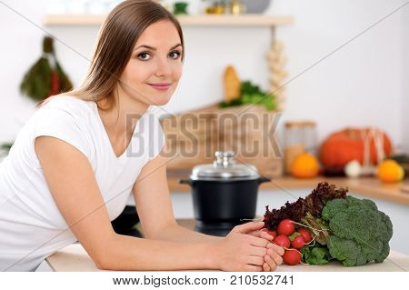 Young woman is making online shopping by tablet computer and credit card. Housewife found new recipe for cooking in a kitchen.
