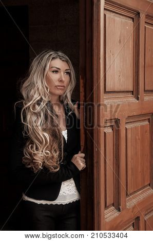 Beautiful Girl Peeks Through The Door, Peeking Out Of Doorway. Girl With Low Lighting, A Massive Doo