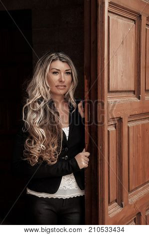 Beautiful Girl Peeks Through The Door, Peeking Out Of Doorway. Girl With Low Lighting, A Massive Doo