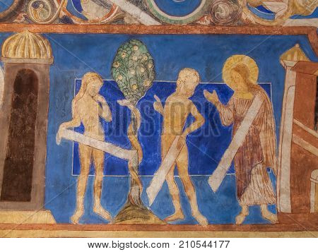 The Fall of Adam and Eve at the Tree of Knowledge. Medieval mural in Bjaresjo church Sweden November 6 2009