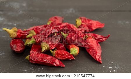 Dried red chili or chilli cayenne pepper. Front wiew on black wooden background