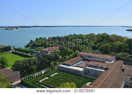 The view from the top of the bellltower of San Giorgio Maggiore church in Venice showing the church courtyards and grounds and the island of San Servol in the background left
