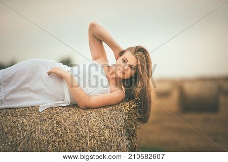 Beautiful Girl On Hay Bales In The Fields