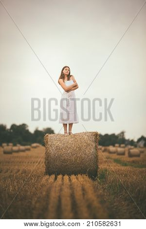 Beautiful Girl On Hay Bales In The Fields
