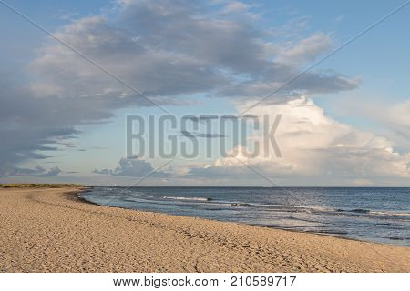 Long beach, blue ocean and blue sky with white clouds, at Grenen Skagen in Denmark