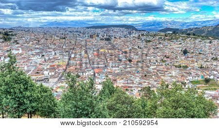 High view of Quito, from the Panecillo hill, on a cloudy and overcast afternoon. Quito, Ecuador.