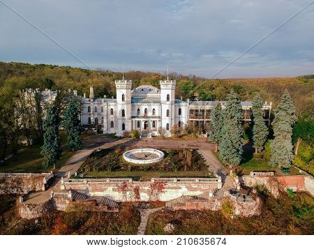 Aerial view on abandoned ruined castle and park. Autumn color image in sunset light.